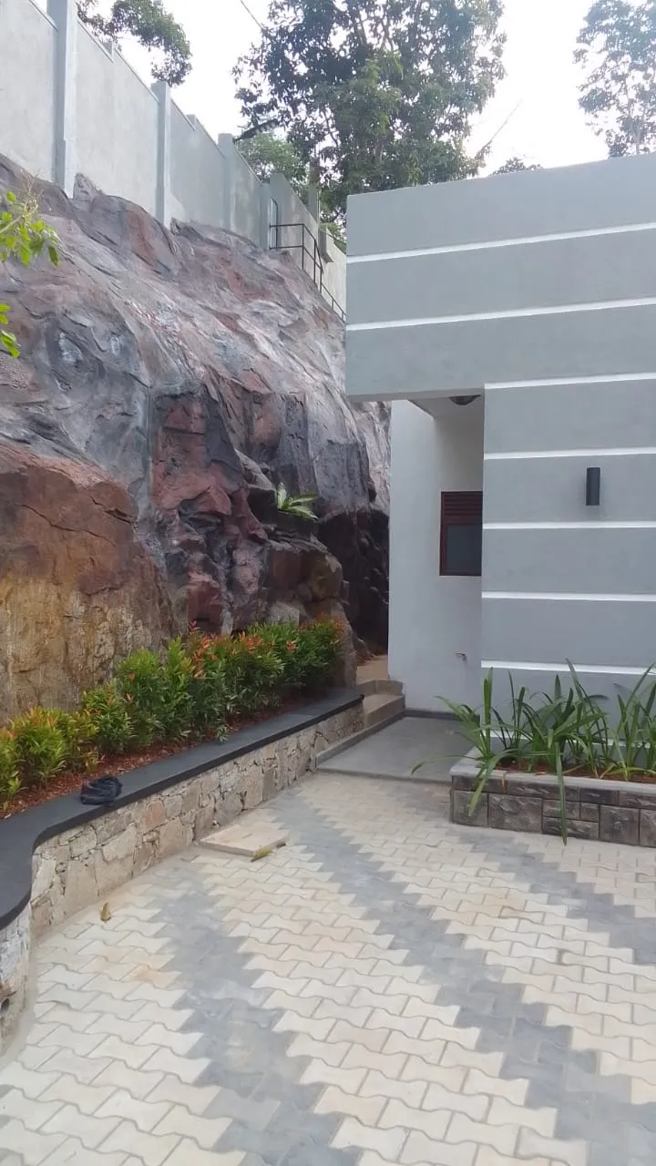 Modern house exterior with natural rock wall and landscaping completed by Unicon Construction near Akurana