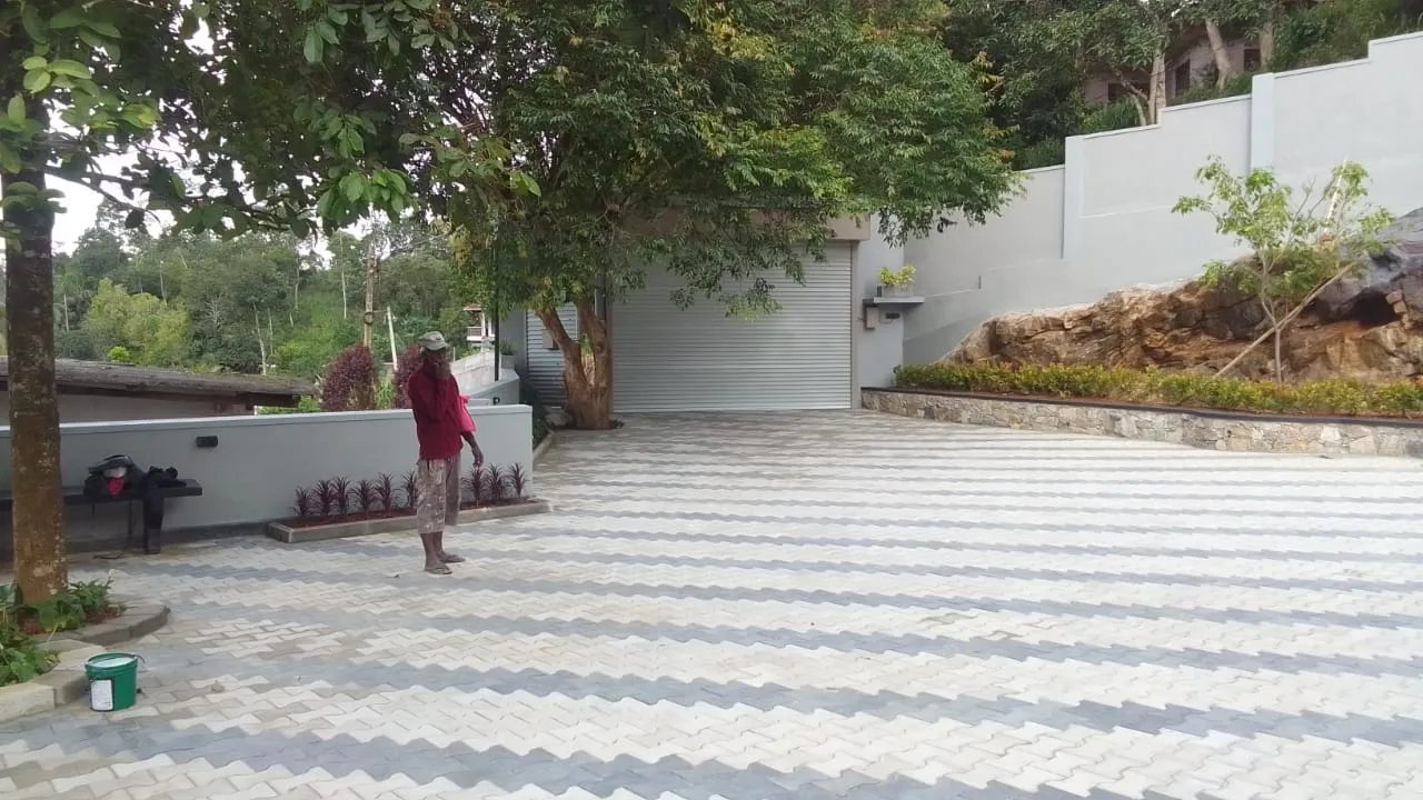 Completed house with paver driveway, garage roller shutter, and landscaping by Unicon Construction