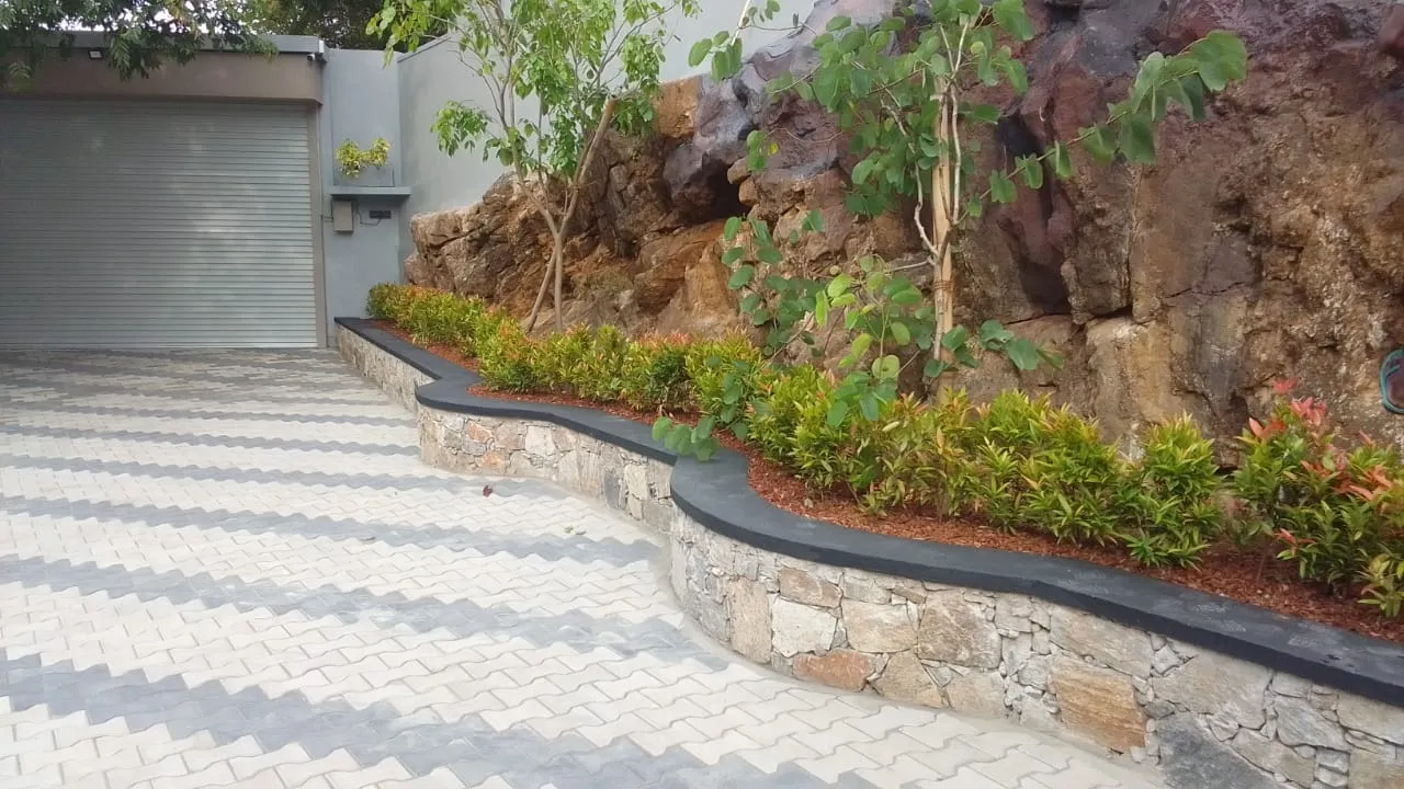 Completed house with stone retaining wall and landscaped garden by Unicon Construction